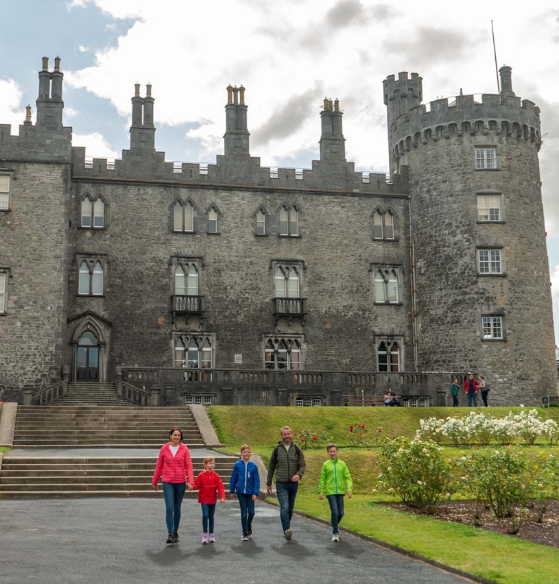 Five people walking outside Kilkenny Castle
